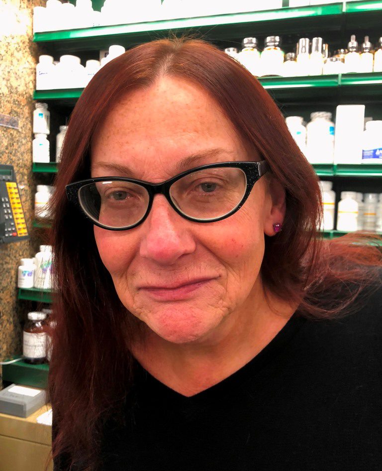 A woman wearing glasses in a pharmacy.